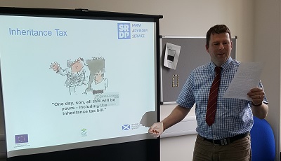 Person giving a presentation with a screen behind him