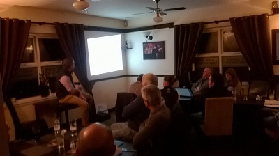 Group of people in a darkened room watching a presentation