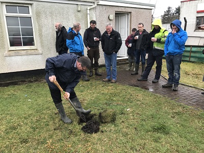 Digging a hole to demonstrate soil drainage
