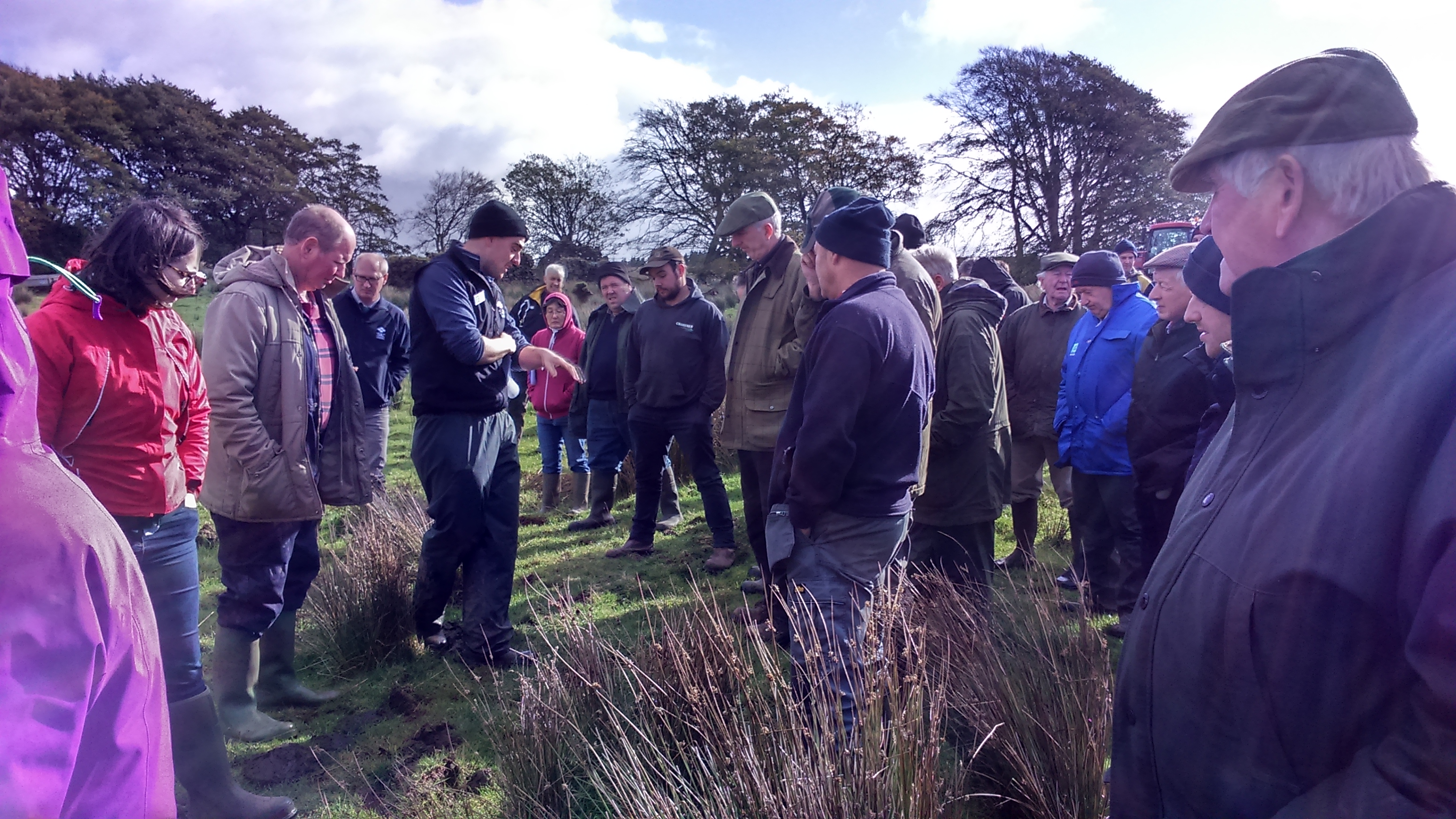 A group of farmers & an agricultural consultant discussing rushes