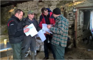 Farmers at the Knockglass Soil & Nutrient Network meeting at Knockglass Farm, Caithness.  They are all looking through handouts from the event