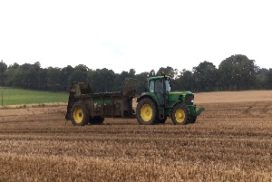 Tractor and muck spreader in a field