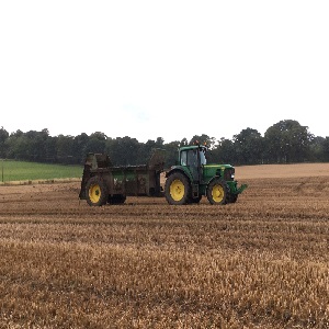 Tractor and muck spreader in a field