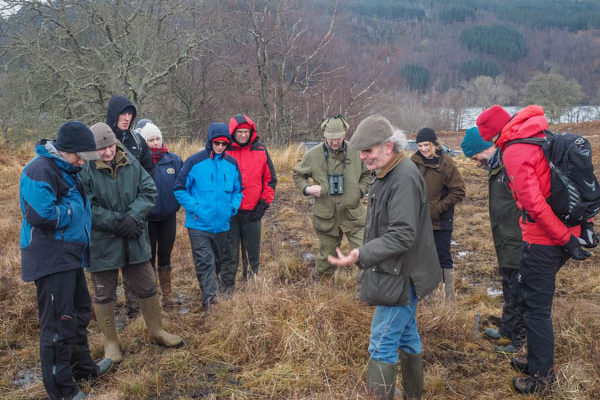 Group of people standing in an upland setting discussing vegetation during the Lochaber Upland habitat meeting