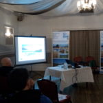 A group of people watching a presentation in a room during the Moray meeting of the ICM roadshow