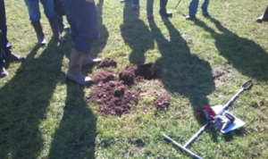 assessing soil structure, people's feet standing around a soil pit