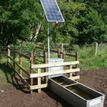 Solar powered water trough with a solar panel above a galvanised trough