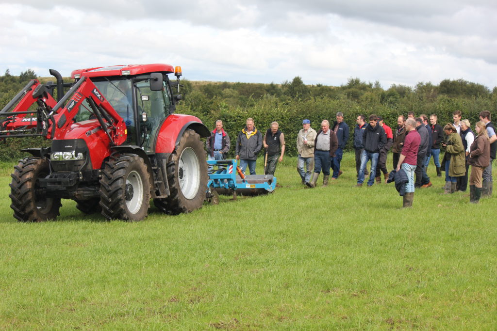 A sward lifter in action with a group of farmers following it to see the impact it has on a grass sward