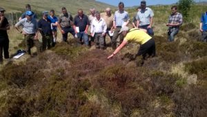Upland habitats event on Jura - a group of people watching how to use a quadrat to assess habitat condition