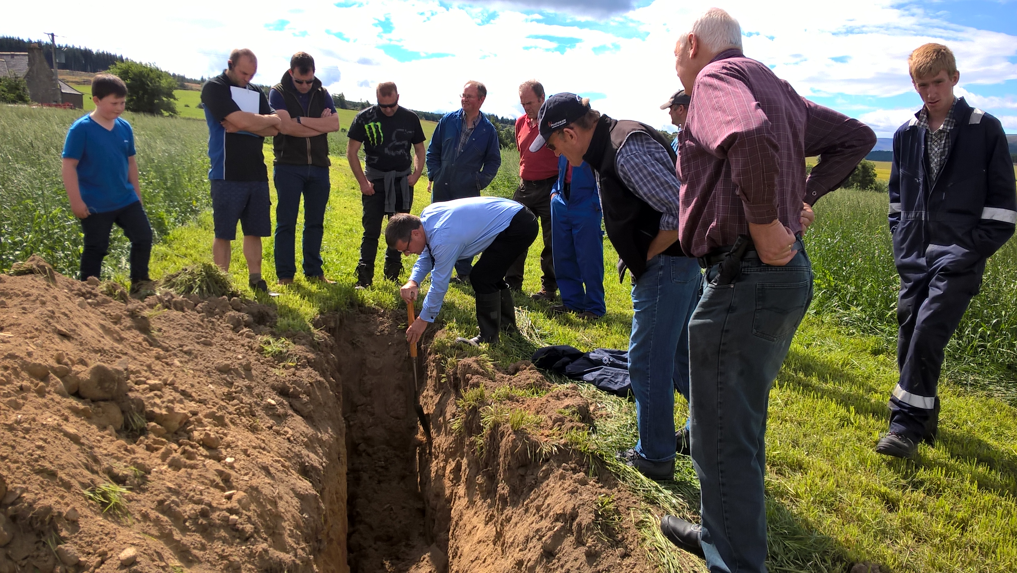Gavin Elrick with a group of farmers examining a soil pit at the Moray SNN meeting