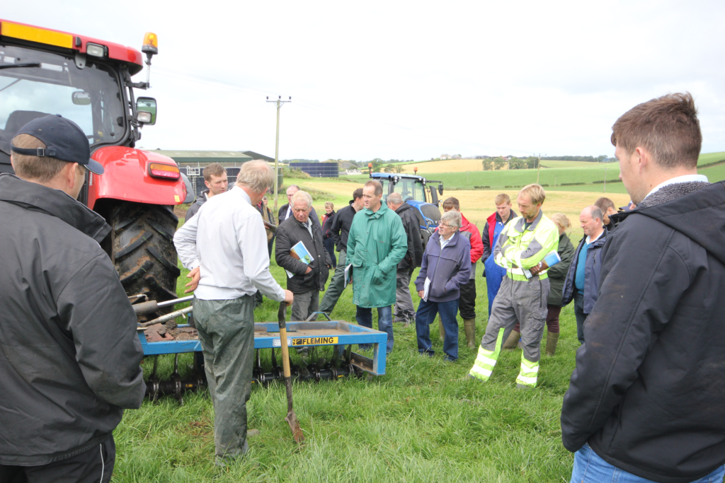 Ayrshire Sol & Nutrient Network - group of people in a grassland field with a tractor and a soil aerator