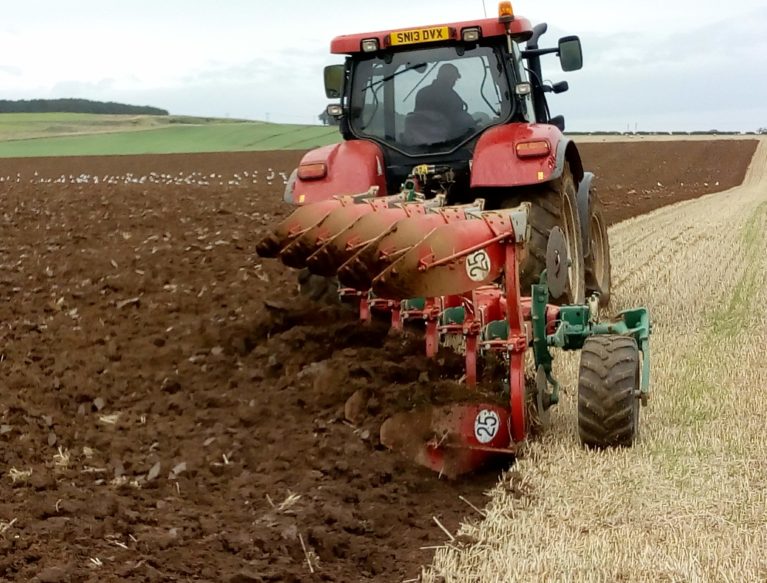 A Case tractor ploughing a field at Bielgrange, the East Lothian Soil & Nutrient Network host farm