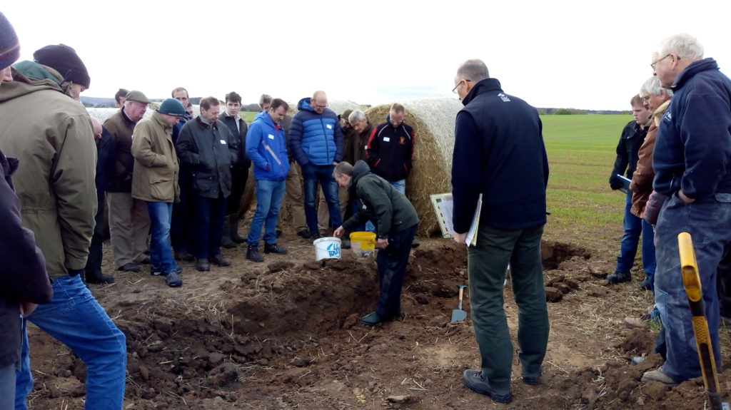 An open soil pit at Bielgrange, the host farm for the East Lothian Soil & Nutrient Network. Brian Griffiths is showing a group of farmers the different soil structure within the ground