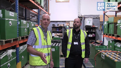 Two people inside a battery manufacturers warehouse