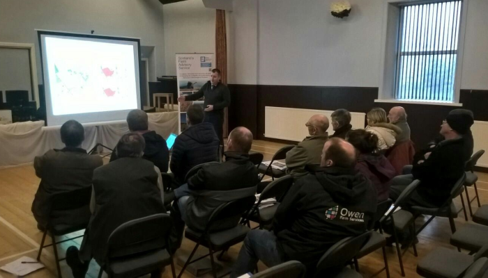 Group of farmers in a hall, listening to a presentation during the final meeting of the Dumfriesshire Soil & Nutrient Network.