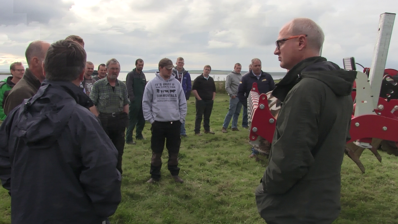 Group of farmers in a field with a sward lifter during the Orkney SNN meeting