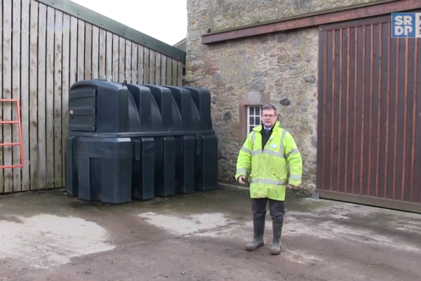 Drainage expert Gavin Elrick standing in a steading beside a bunded fuel tank