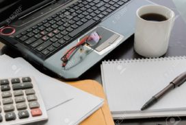 Computer and calculator, cuppa and notebook and pen