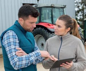 Tractor, 2 people discussing item on tablet