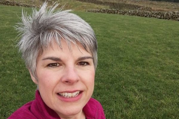 Smiling woman with green field in the background