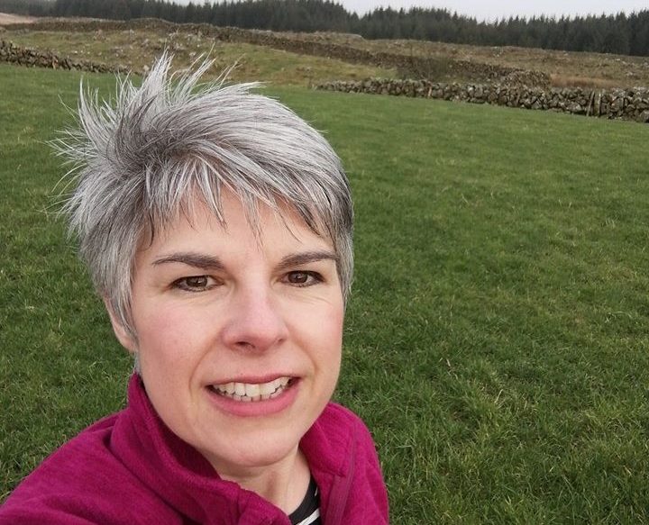 Smiling woman with green field in the background