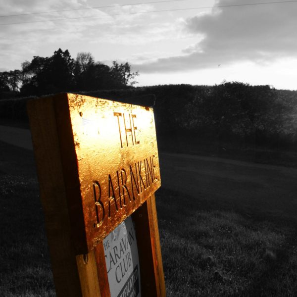 A sign for The Bairnkine Farm, with a sign below it for the caravan club.