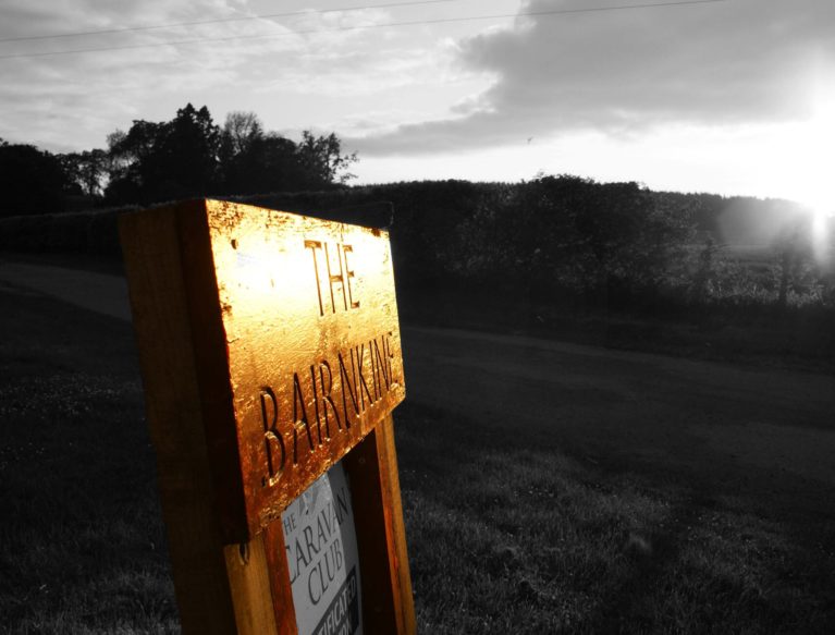 A sign for The Bairnkine Farm, with a sign below it for the caravan club.