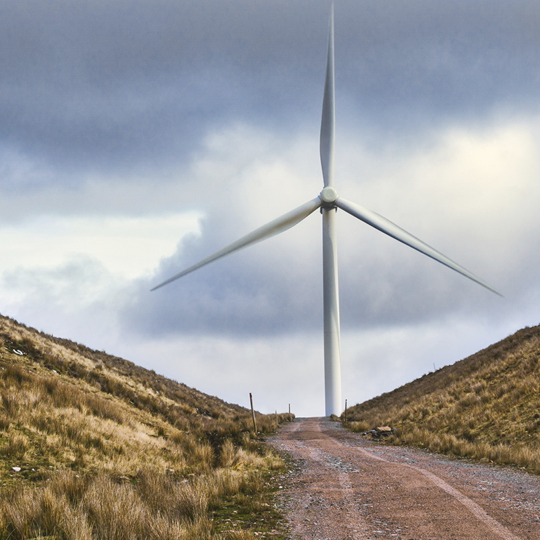 Wind turbine on top of a hill at the end of a road