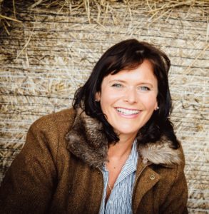 Picture of Heather Wildman sitting in front of bales