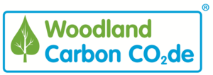 Woodland Carbon Code logo - a white background with a green leaf shaped tree on the left hand slide, with the word 'Woodland' in green text sitting above the words ;Carbon Co2de' in a bright blue font below, both sitting to the right of the tree and all enclosed within a round edged blue border.