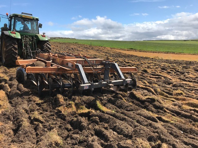 Tractor with disc harrower on soil