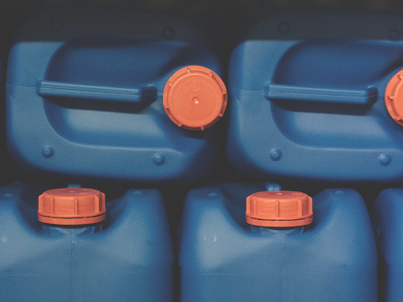 Two blue 5 gallon jars sitting upright with a futher two jars stacked on top on their sides. The photo is at 80 percent opacity