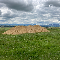 Grassland field with a huge heap of liming product in the middle of the photo.