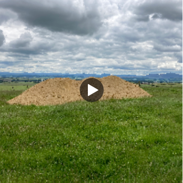 A pile of soil in the middle of a field