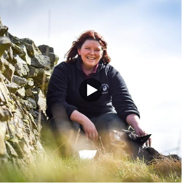 Jen Craig sat on a hill, smiling.