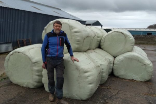 Donald Barrie standing in front of wrapped silage bales