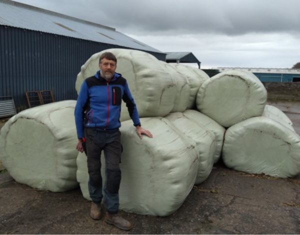 Donald Barrie standing in front of wrapped silage bales