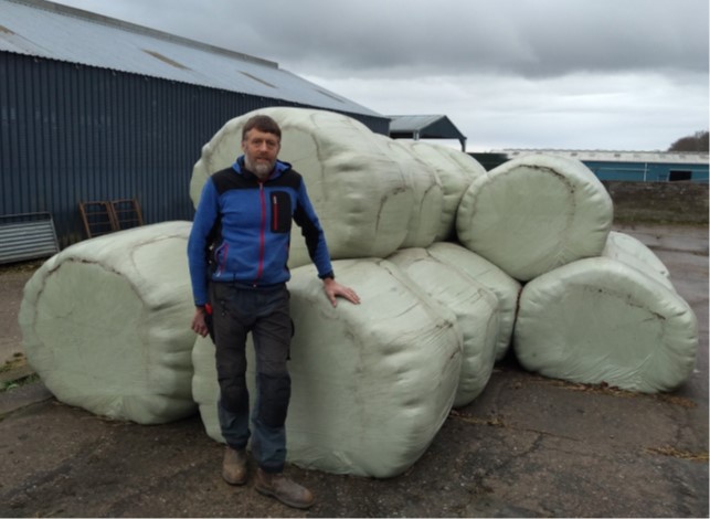 Donald Barrie standing in front of wrapped silage bales