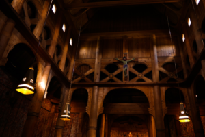 The wooden interior of a stavkirker including the carving details of the structure and decoration.