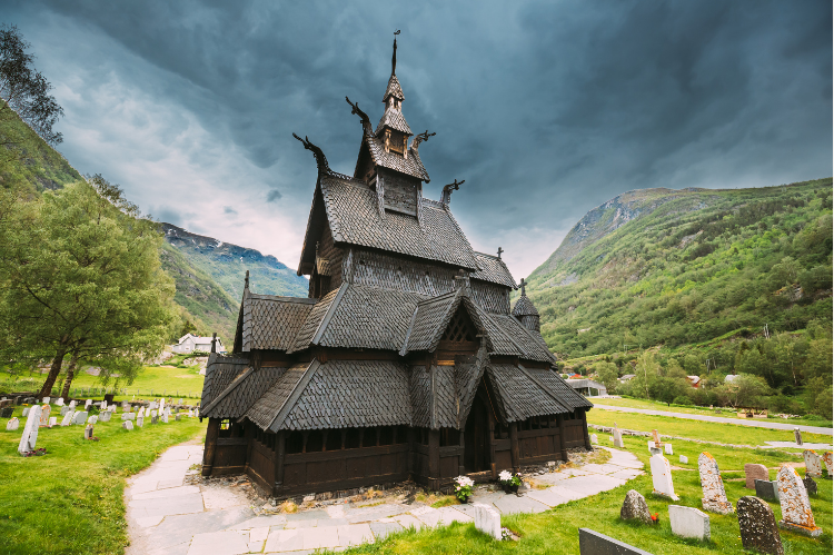 A wooden stave church in a valley in Norway.