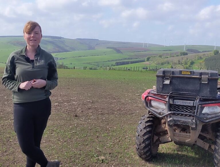 a woman standing next to an atv in a field.