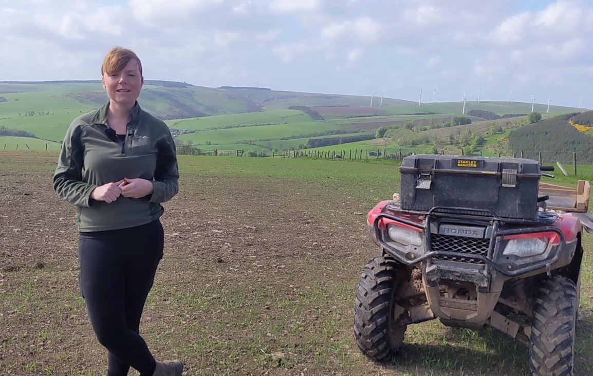 a woman standing next to an atv in a field.
