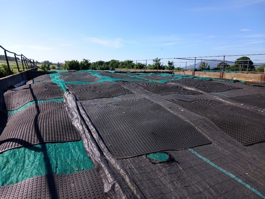 Heavy rubber mats providing even weight distribution on an outdoor silage clamp.