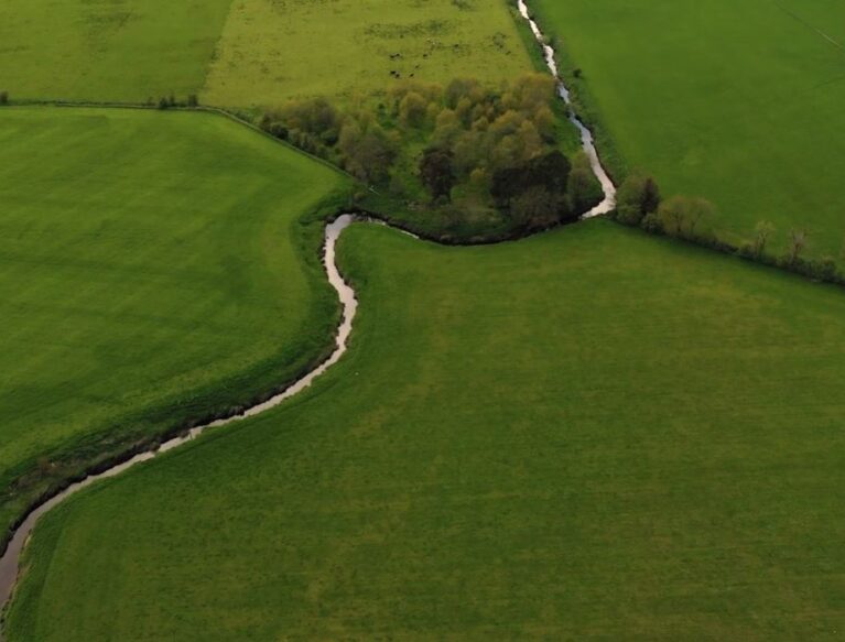 Arial footage of a steam through fields