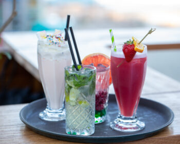 Colourful drinks and a milkshake on a tray